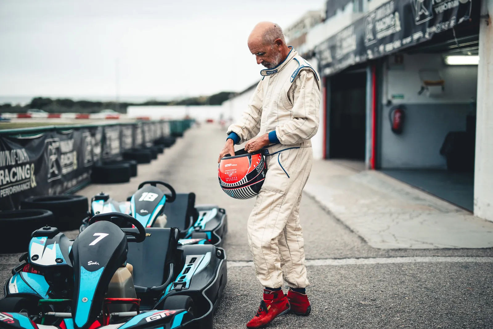 Domingos in the pit lane beside the karts, helmet in hand