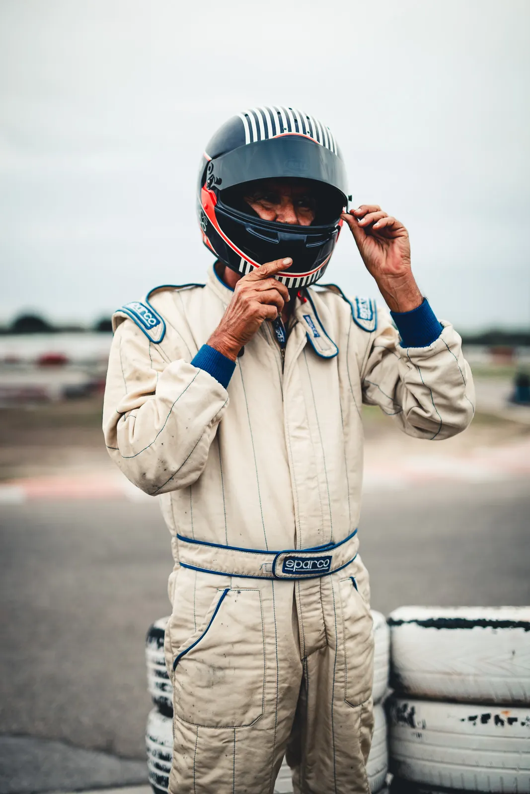 Domingos adjusting his helmet by the tyre wall